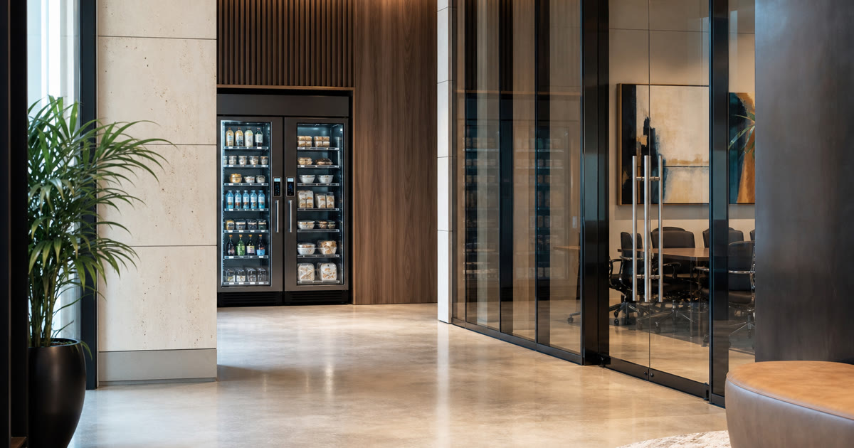 Revvolto smart vending cooler in an Austin business event lounge with stocked clear glass shelves