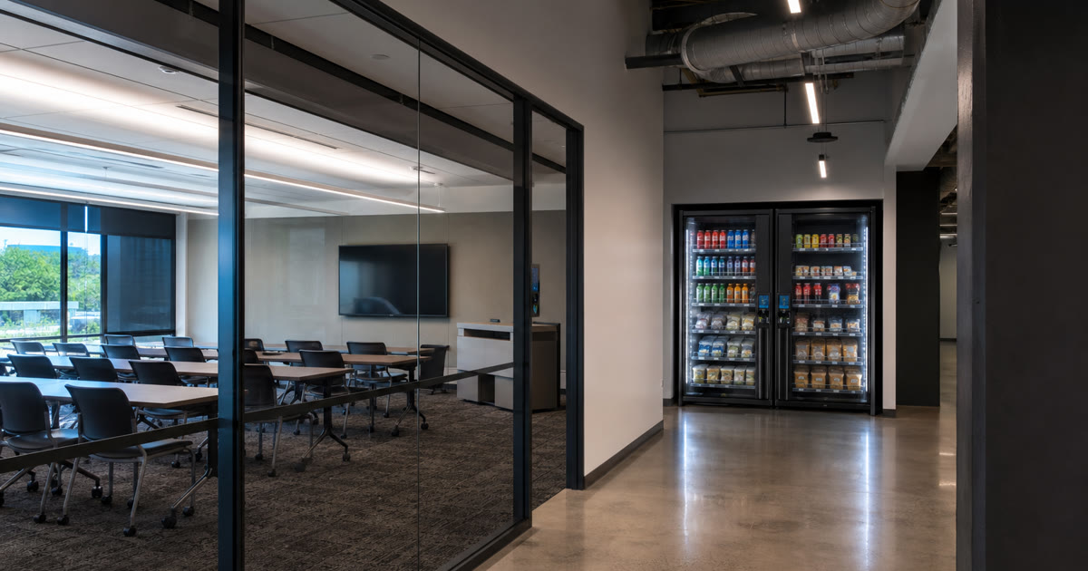 Revvolto smart vending cooler near an Austin industrial training room with stocked glass doors