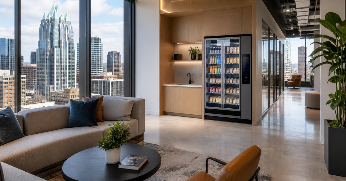 Revvolto smart vending cooler inside a renovated Austin office lounge with stocked glass doors and handle display