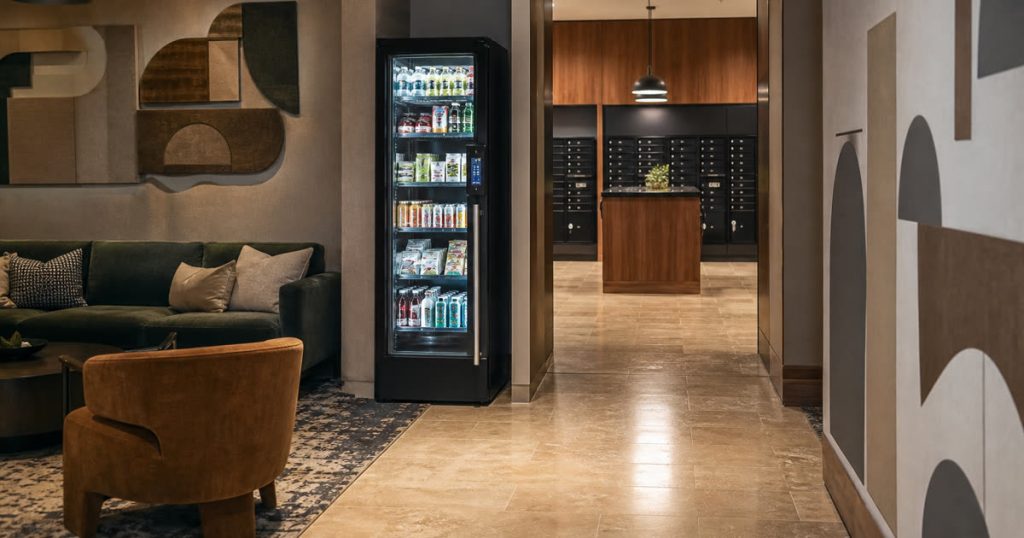 Revvolto smart cooler in a mixed-use building lobby near package pickup and shared seating