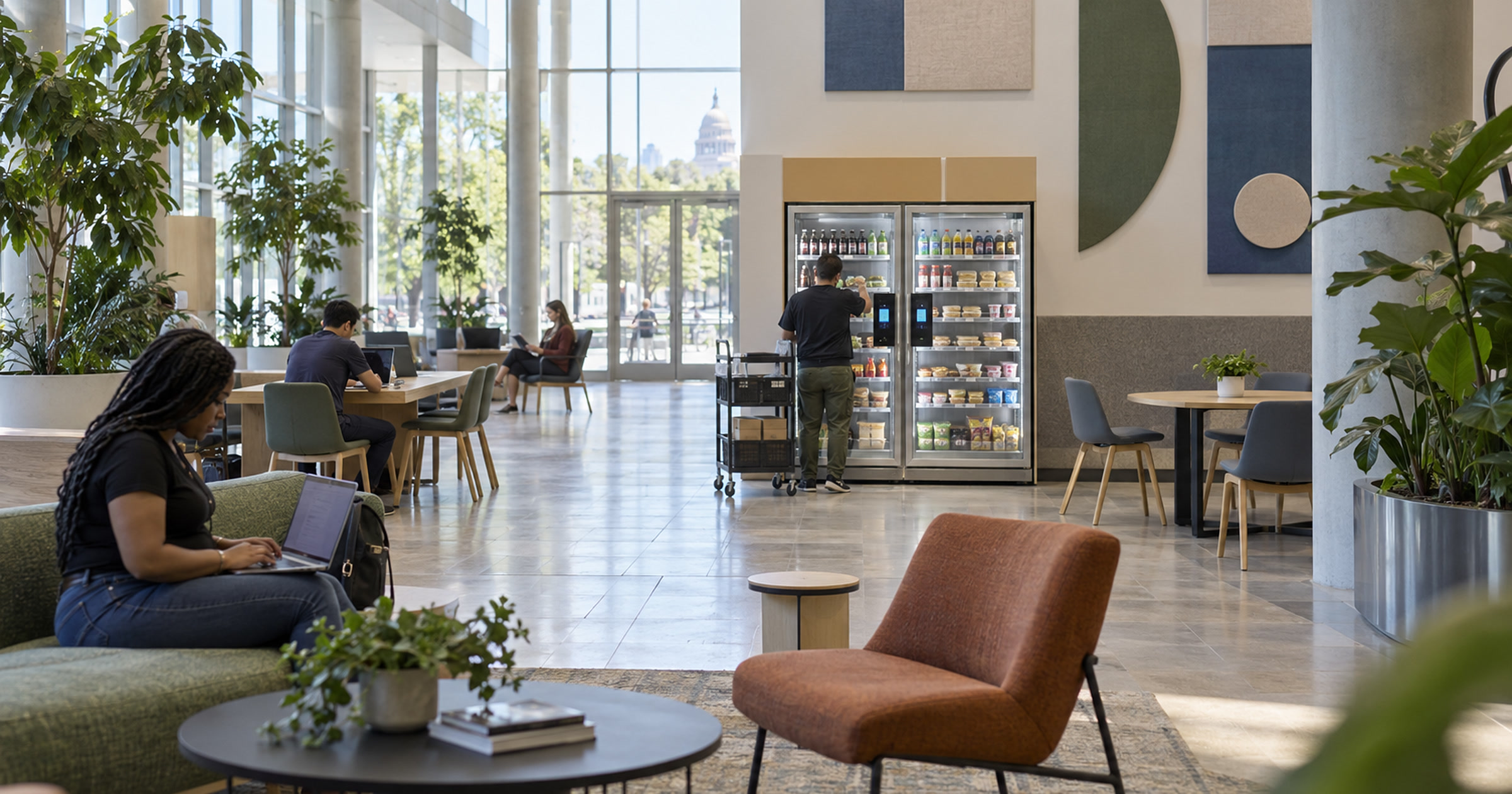 Revvolto refrigerated vending unit in a skylit civic community space with a non-identifiable restocking moment
